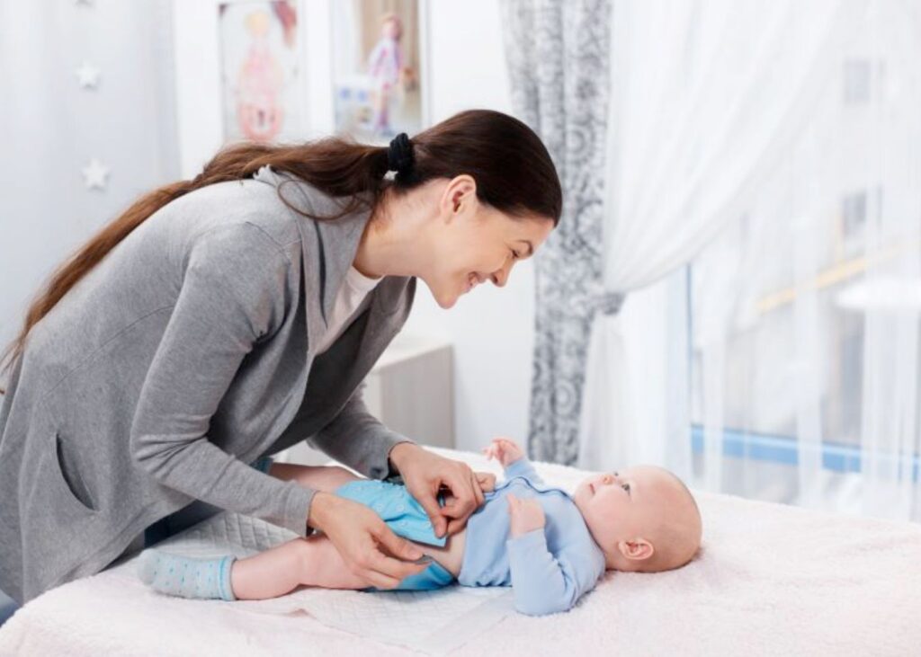 Mum changing reusable nappy on baby