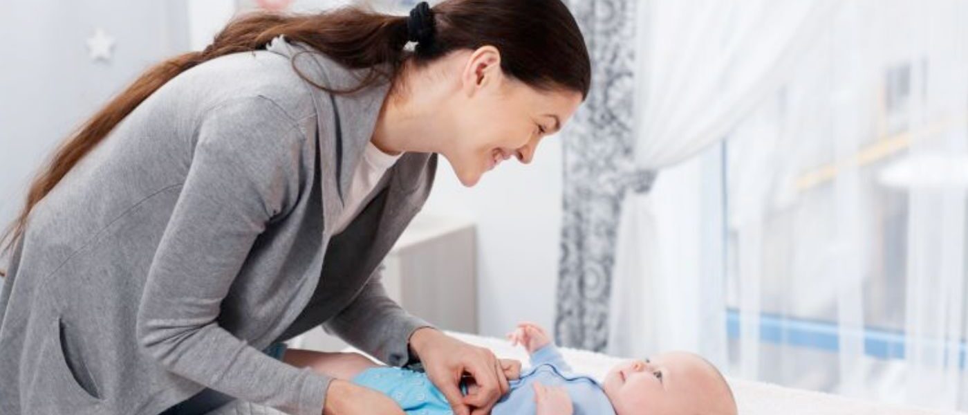 Mum changing reusable nappy on baby