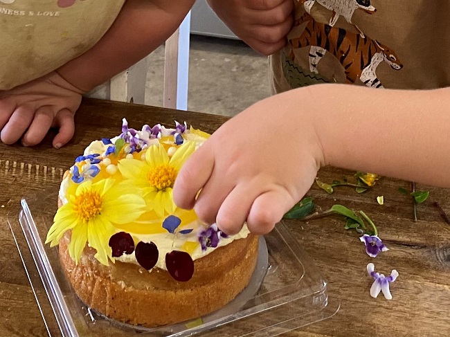 kids decorating cake with edible flowers