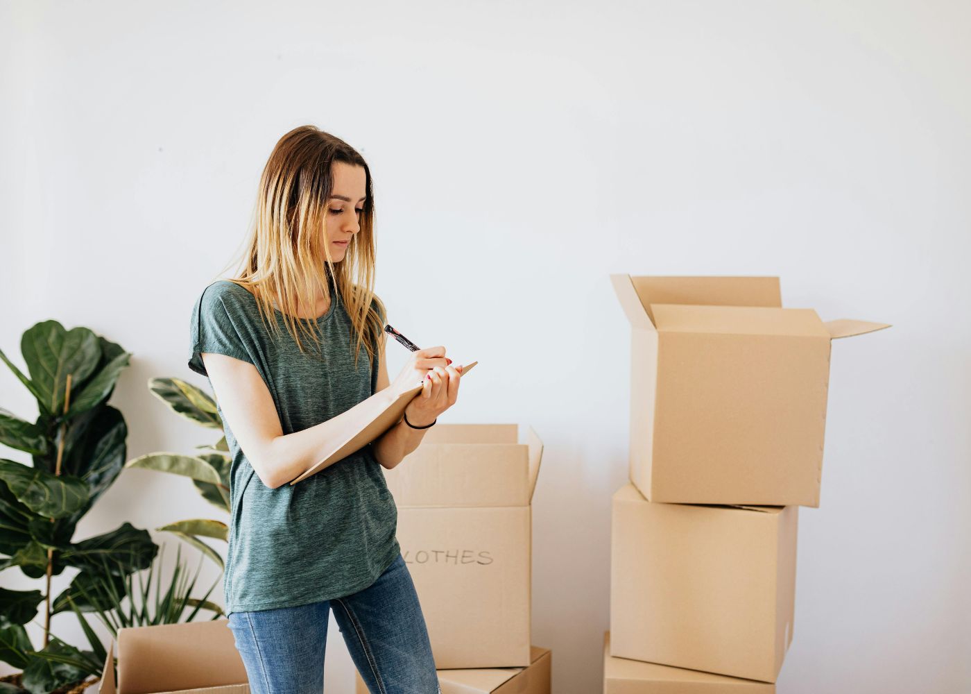 Work-from-home mum writing checklist for moving into a new home