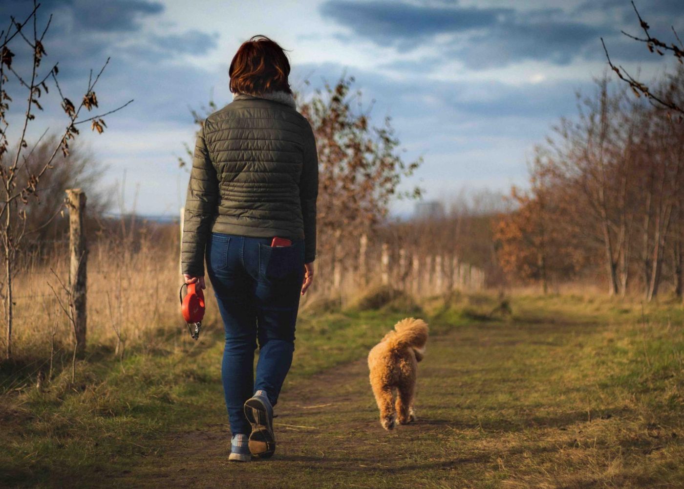 A woman taking a stroll with her dog to mark end of a working day when working from home